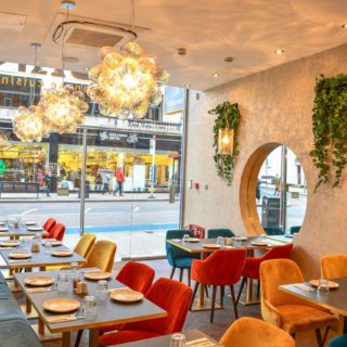 Black Pietra Grigia Marble tabletops and Inox brass bases at Libano restaurant Balham London by DeFrae Contract Furniture