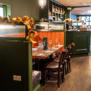 Banquette seating and restaurant chairs supplied by DeFrae Contract Furniture for a steakhouse interior, featuring fluted back booths, solid wood tables, and Crib 5 upholstery.
