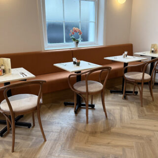 Interior of Peach Hertford showing classic bentwood restaurant chairs and banquette seating