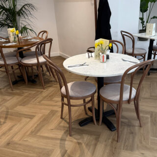 Warm brunch interior at Peach Hertford with bentwood chairs and marble tables
