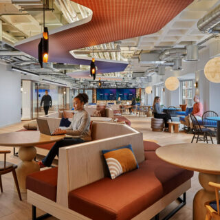 Open plan workspace and breakout seating areas at Talon OOH London headquarters featuring upholstered bench seating within a collaborative office environment.